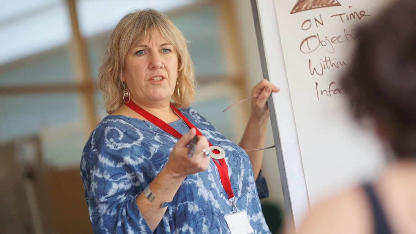 English teacher at the whiteboard presenting a grammar point built from ChatGPT prompts
