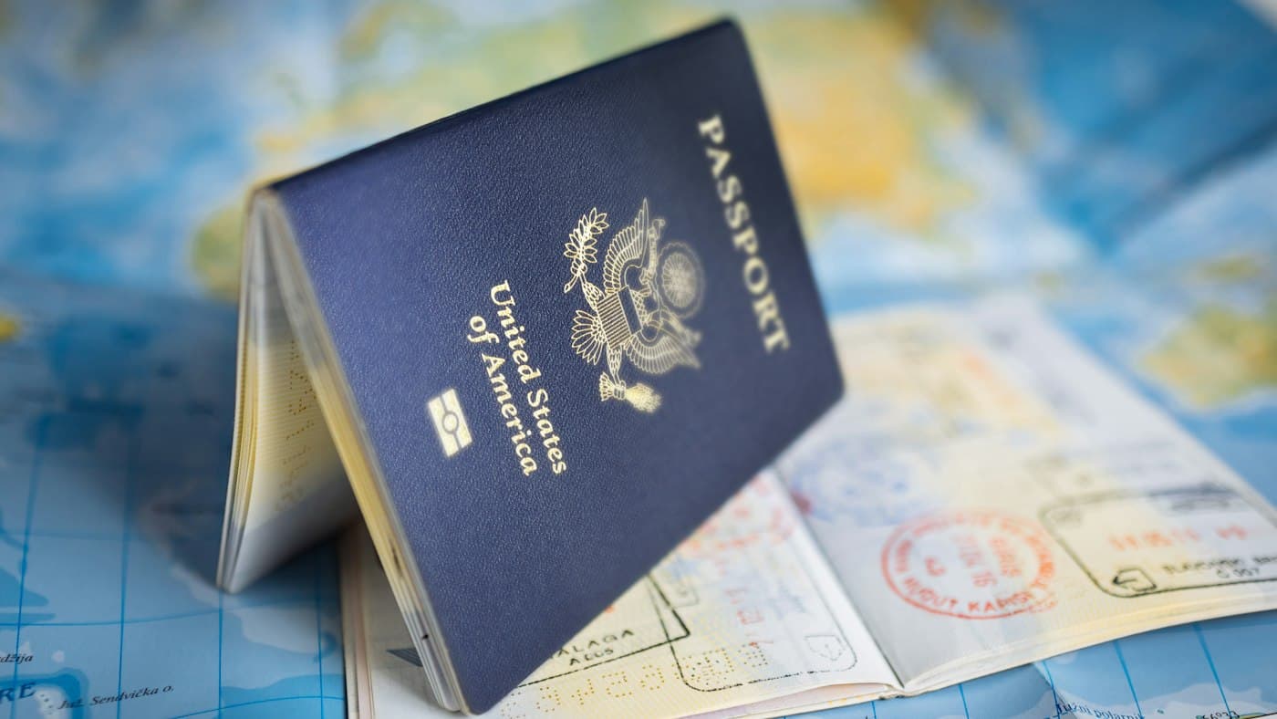 Passport lying open on a world map showing where you can teach English abroad