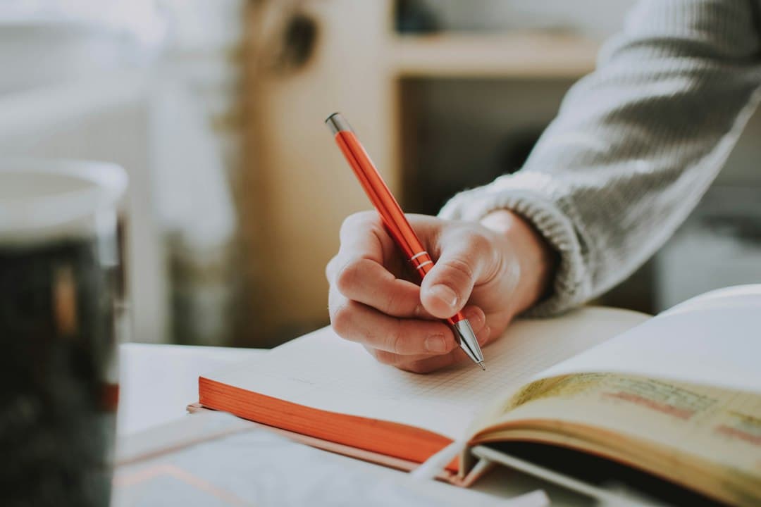 Teacher marking a learner's English writing in red pen for first language interference errors